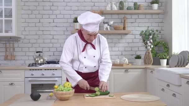 Starszy szef kuchni kroi warzywa w restauracji. Proces gotowania przez profesjonalistę — Wideo stockowe