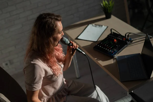 Cantora feminina expressiva tem um vídeo blog em um laptop. Retrato de uma menina gravando uma música em uma câmera web e compondo em um sintetizador. Aulas de música online. Ensino à distância em quarentena. — Fotografia de Stock