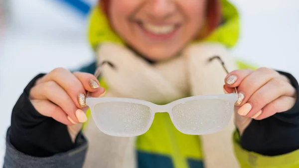 Glimlachende blanke vrouw doet 's winters bevroren glazen buiten af. Het meisje heeft het koud.. — Stockfoto