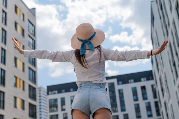 Vista trasera de una mujer en un sombrero sentado en el fondo de la ciudad —  Fotos de Stock