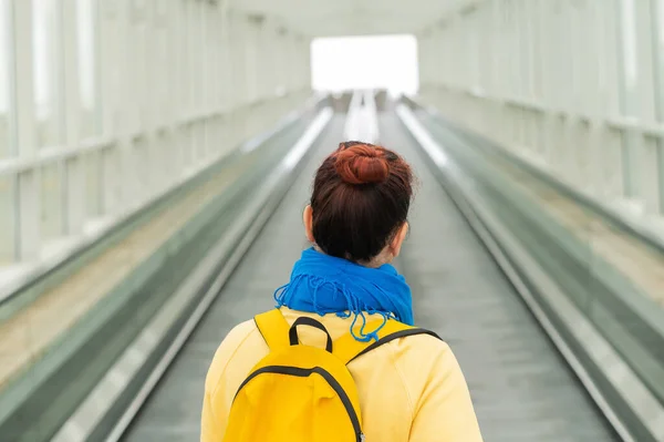 Vista posterior de la mujer con la mochila en movimiento en escaleras mecánicas. —  Fotos de Stock