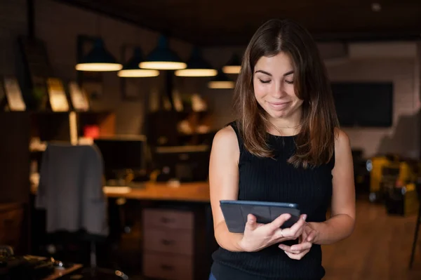 Belle femme d'affaires portant dans un casque tient une tablette numérique dans le bureau — Photo