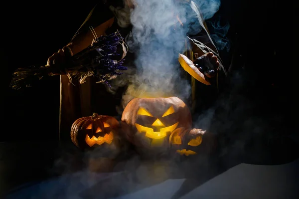 Czarownica rzuca zaklęcie na parującą dynię w ciemności w Halloween — Zdjęcie stockowe