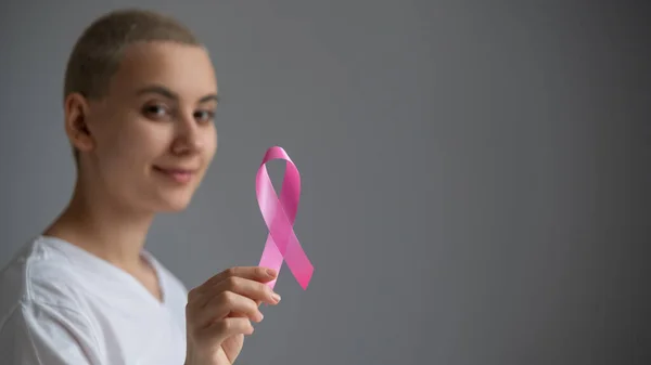 Young woman with pink ribbon on a white background. Mammary cancer — Stock Photo, Image