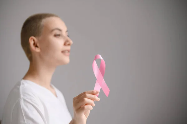 Young woman with pink ribbon on a white background. Mammary cancer — Stock Photo, Image