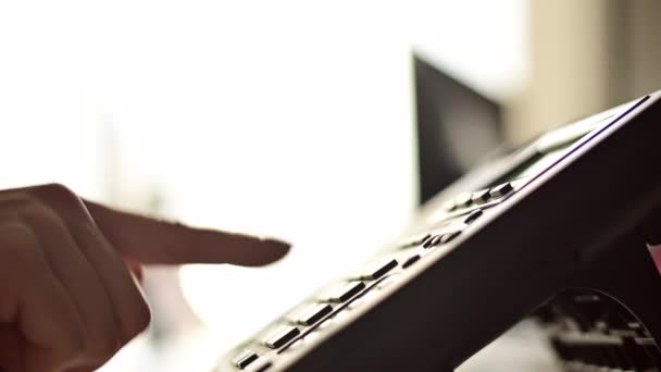 Close-up of the hand of a female office worker dialing a number on a landline phone. Faceless woman secretary calls on the phone — Stock Video