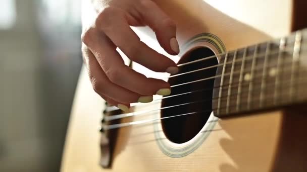 Primer plano de las manos femeninas en una guitarra acústica. La chica aprende a tocar la guitarra — Vídeos de Stock