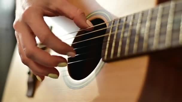 Close-up van vrouwelijke handen op een akoestische gitaar. Het meisje leert gitaar spelen. — Stockvideo