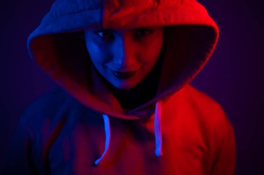 Kapüşonlu, neon ışıklı güzel bir kadının portresi.
