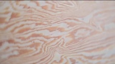 Kırmızı gül yaprakları, ahşap bir arka planda kalp şeklinde merkeze doğru akın eder.