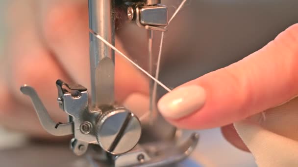 Primer plano. Una mujer está cortando el hilo en una máquina de coser eléctrica — Vídeo de stock