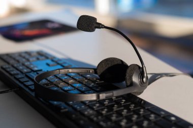 Bilgisayar klavyesinde mikrofon olan kulaklık. Çağrı merkezi operatörlerinin çalışma yeri