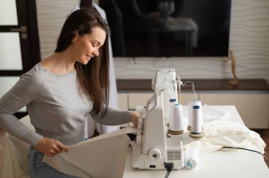 Kafkasyalı kadın evde sipariş veriyor. Oturma odasında bir terzinin çalışma odası.