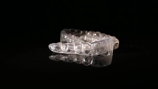 Removable plastic retainers spin against a black background — Stock Video