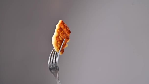 Tenedor con una rebanada de rollos de queso frito sobre un fondo blanco. — Vídeos de Stock