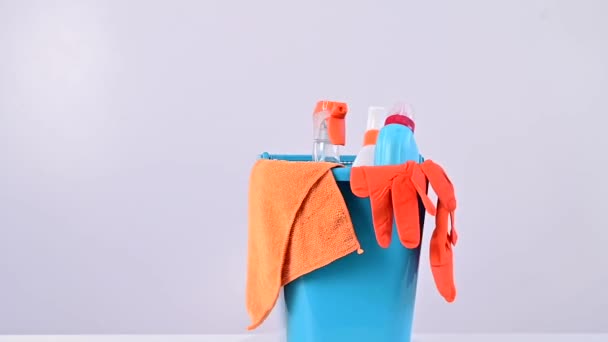 蓝色水桶，装有清洁用品和用于作业的橡胶手套，在白色背景上旋转 — 图库视频影像