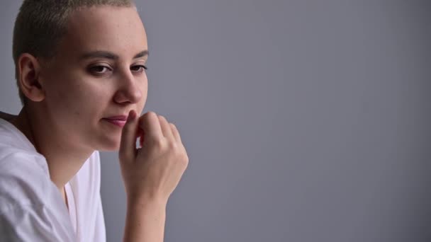 Emaciated young woman with short hair yawns on white background. — Stock Video