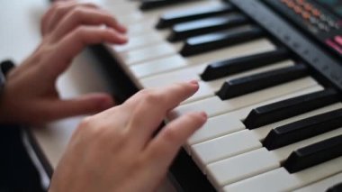 Piyano tuşları üzerinde kadın elleri yakın çekim. Elektrikli sentezleyici oynayan kadın.