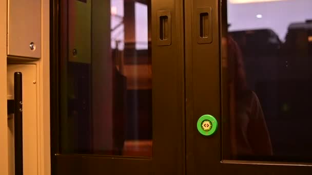 Vit rödhårig kvinna kliver in i tågvagnen genom att trycka på knappen för att öppna dörrarna — Stockvideo