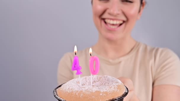 幸せな女性は願い事をし、 40歳の誕生日ケーキにろうそくを吹き消します。誕生日を祝う女の子. — ストック動画