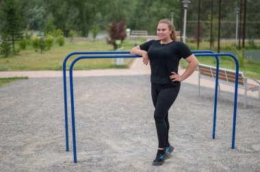 Düz olmayan barlarda poz veren şişman genç kadın..
