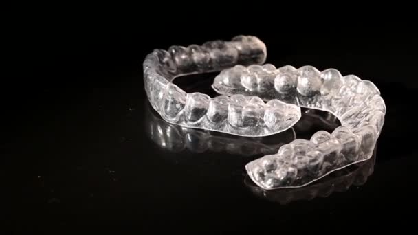 Braces amovibles transparentes tourbillonnent sur un fond noir — Video