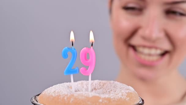 La mujer feliz pide un deseo y sopla las velas en el pastel de cumpleaños 25. Chica celebrando cumpleaños. Movimiento lento. — Vídeo de stock