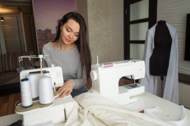 Kafkasyalı kadın evde sipariş veriyor. Oturma odasında bir terzinin çalışma odası.