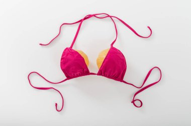 Beyaz arka planda balkabağı sütyeni. Bikinili iki balkabağı. Boşluğu kopyala