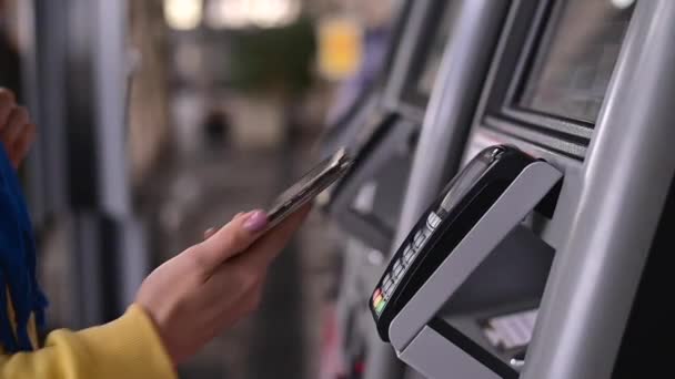 Nahaufnahme einer Frau, die an einem Selbstbedienungsautomaten mit einer kontaktlosen Telefonzahlung bezahlt — Stockvideo
