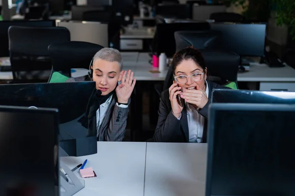 Mujer joven curiosa escucha una conversación telefónica privada de un colega en la oficina — Foto de Stock