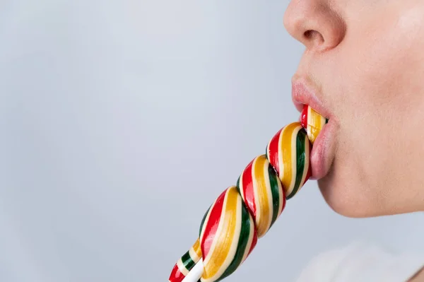 Close-up portrait of a woman sucking a long lollipop against a white background. Blowjob simulation — Fotografia de Stock