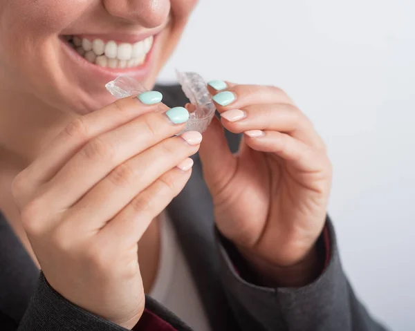 Şeffaf plastik diş teli takan bir kadının yakın çekimi. Kız dişlerini düzeltmek için bir cihaz kullanıyor. — Stok fotoğraf