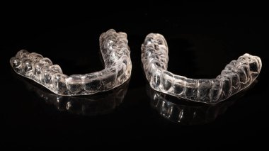 Siyah arkaplandaki ısırık düzeltmeleri için çıkarılabilir plastik diş telleri