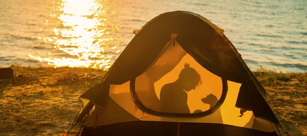 日没の観光テントの中で女性と犬。ペットとキャンプ — ストック写真