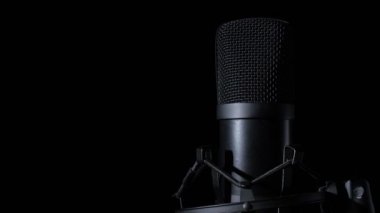 Siyah arka planda dönen bir mikrofonun yakın plan görüntüsü. Boşluğu kopyala.