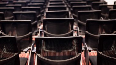 Konferans odasında sıra sıra boş sandalyeler.