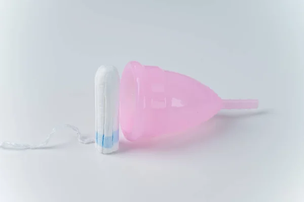 Roze menstruatiecup en tampon op een witte achtergrond. Diverse hygiëneproducten tijdens de menstruatie — Stockfoto