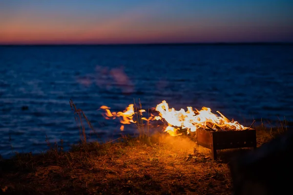 日落时从海滨篝火上的旅游帐篷观看 — 图库照片