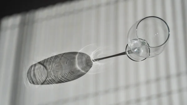 Blinds shade on a wine glass on a white table — Stock Photo, Image