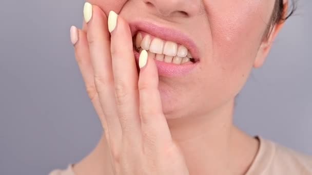 Retrato de cerca de una mujer caucásica que sufre de dolor de muelas. La niña es atormentada por el dolor de la caries — Vídeos de Stock