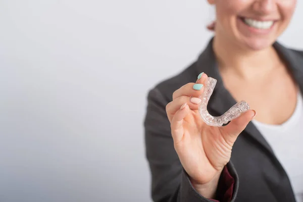 Smiling woman demonstrates mouth guards for bite alignment. The girl approves of the plastic removable braces for the teeth — Stock Photo, Image