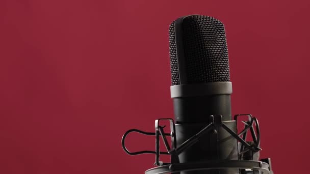 El micrófono gira sobre un fondo rosa. Equipo de estudio de grabación profesional en rotación — Vídeo de stock