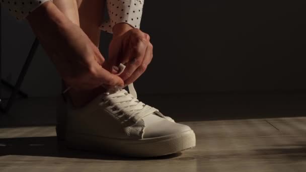 Kvinna sätta på nya vita läder sneakers — Stockvideo