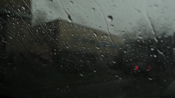 Вид на дорогу из машины через лобовое стекло под дождем. — стоковое видео