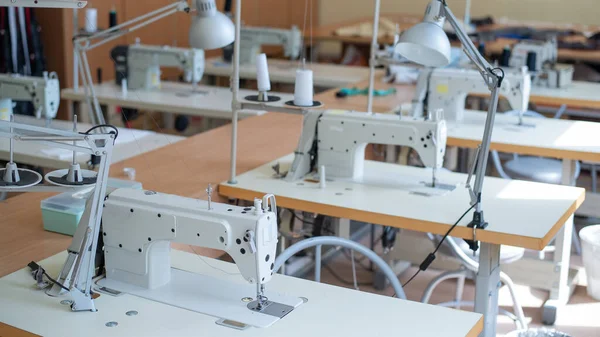 Ambiente de trabajo taller de costura. Industria de la confección. Lugares de trabajo vacíos de costureras —  Fotos de Stock
