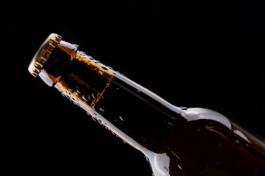 Siyah arka planda yoğunlaşması olan koyu cam bira şişesi..