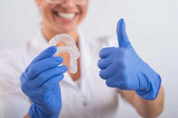 El ortodoncista sostiene los retenedores transparentes extraíbles — Foto de Stock