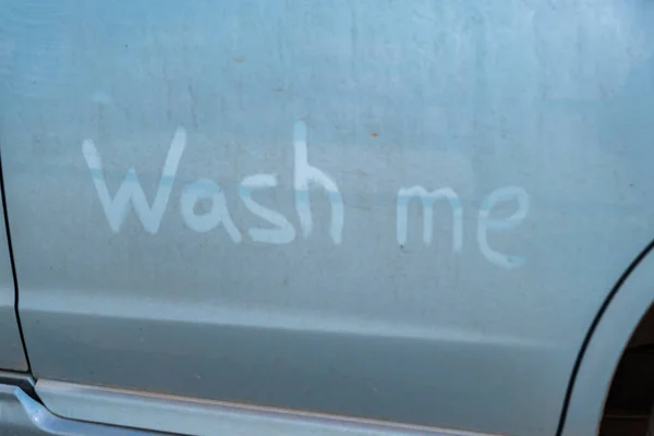 Las letras de dedo me lavan en un coche azul sucio. — Foto de Stock