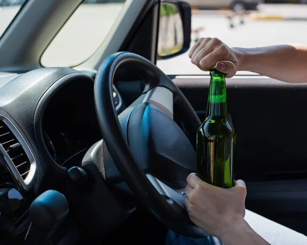 Yüzsüz bir kadın araba sürerken bir şişe bira açar. Kanunları çiğnemek ve araba kullanırken alkol içmek. — Stok fotoğraf